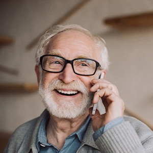 Senior man with glasses talking on phone