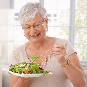 Senior woman with glasses eating a salad