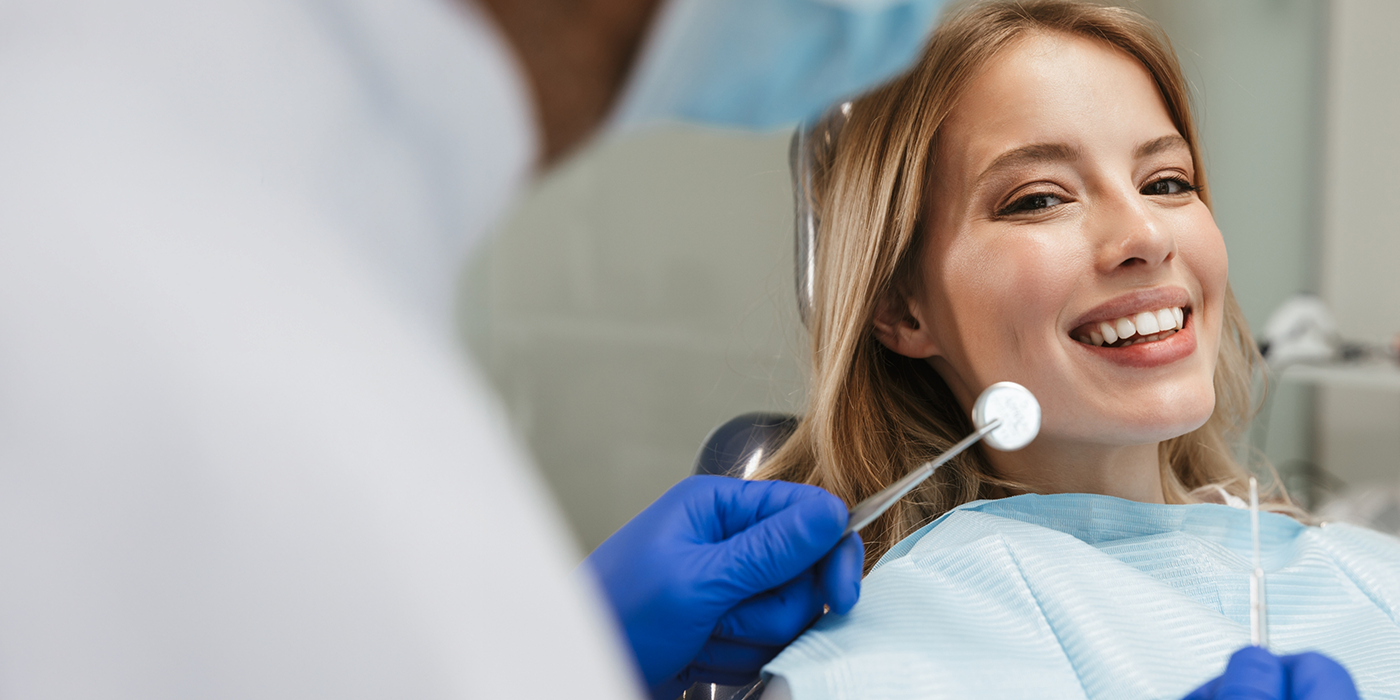 Woman smiling during a checkup with her dentist in Fort Worth