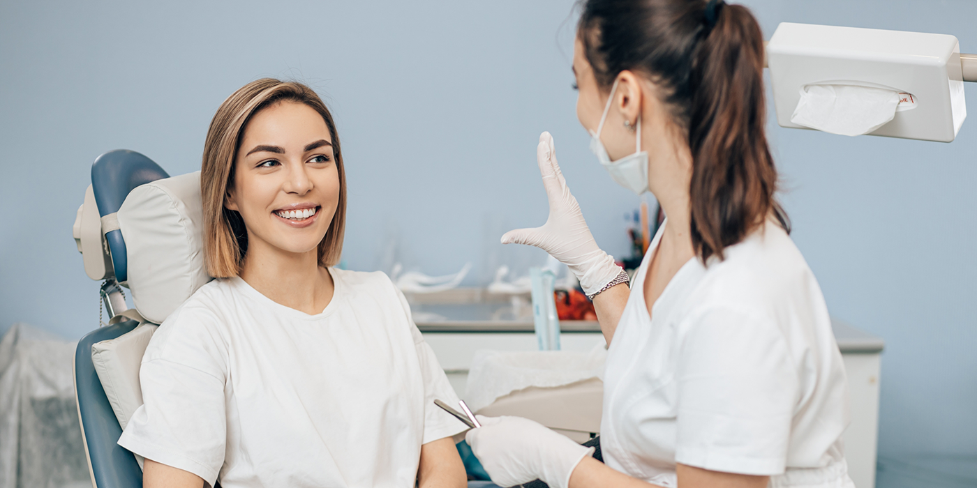 Dentist talking with a patient in the treatment chair