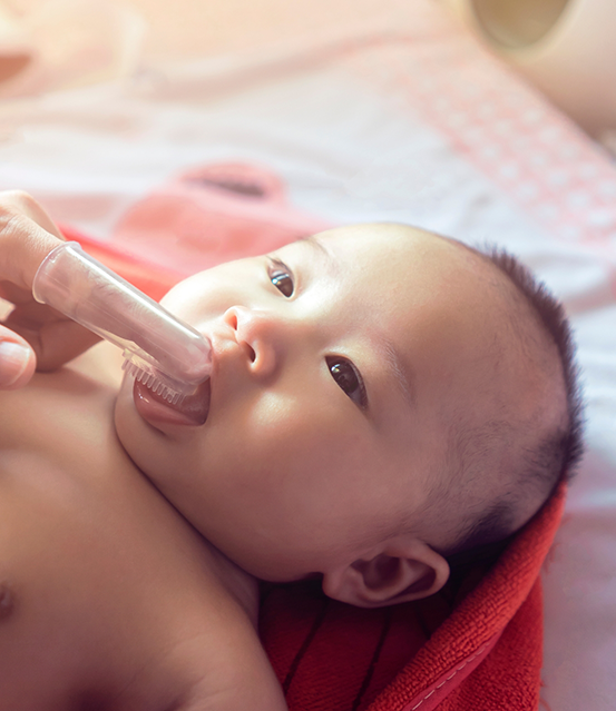 Parent cleaning their baby's gums