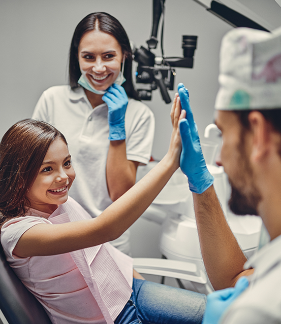 Girl giving a high five to her dentist