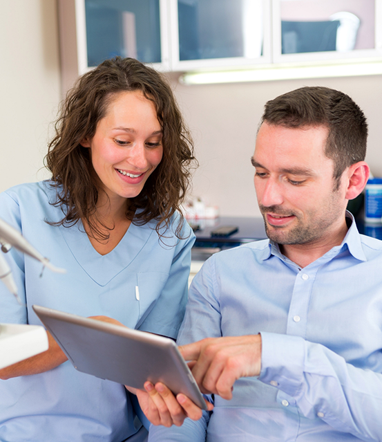 Dentist showing a tablet screen to a patient