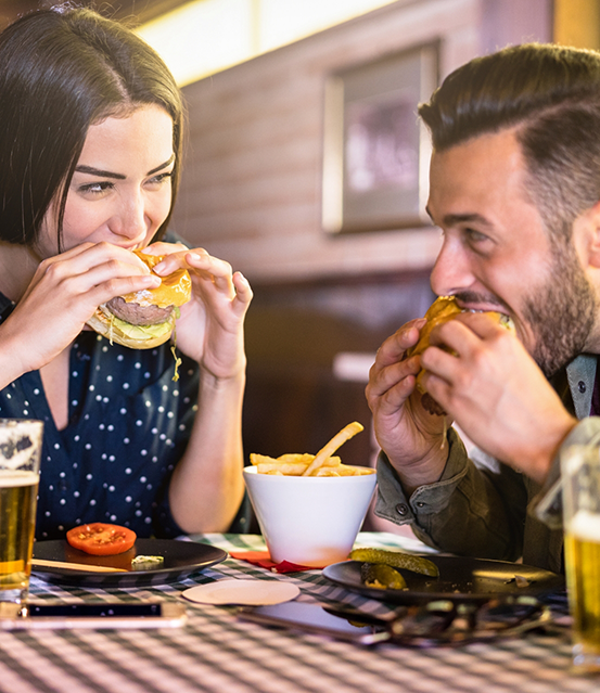 Man and woman eating burgers
