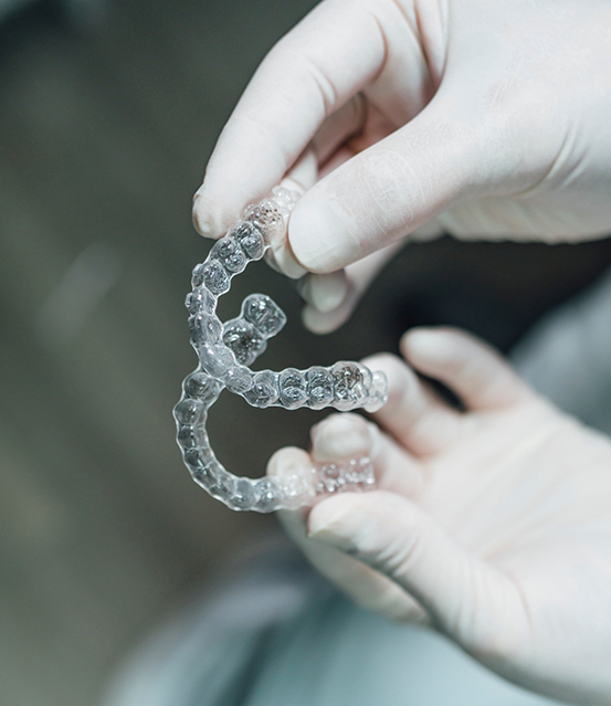 Dentist holding an Invisalign aligner