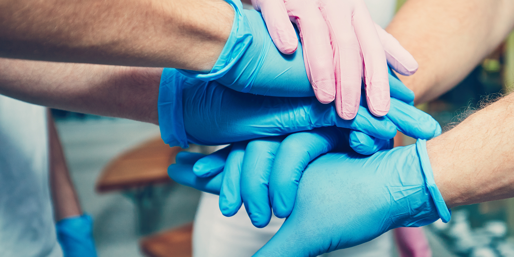 Fort Worth dental team members placing their hands together in the middle of a circle