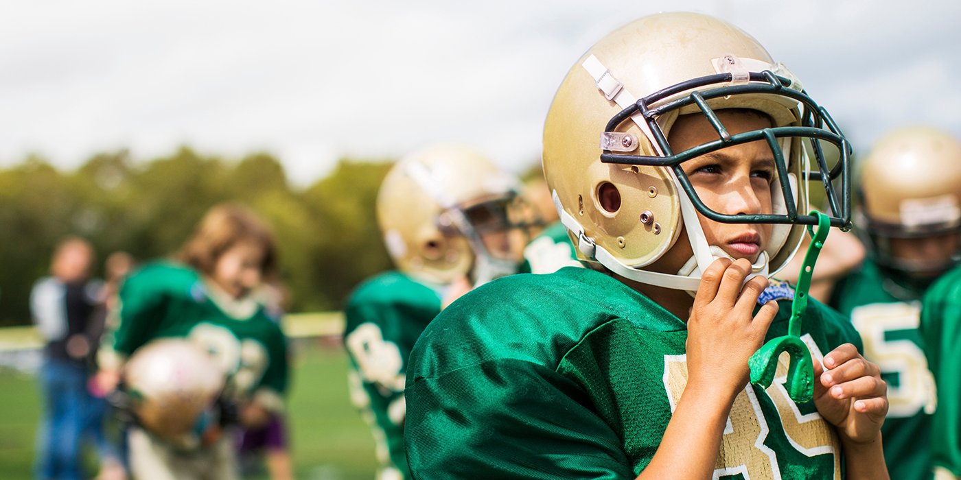 Football player with a mouthguard attached to their helmet