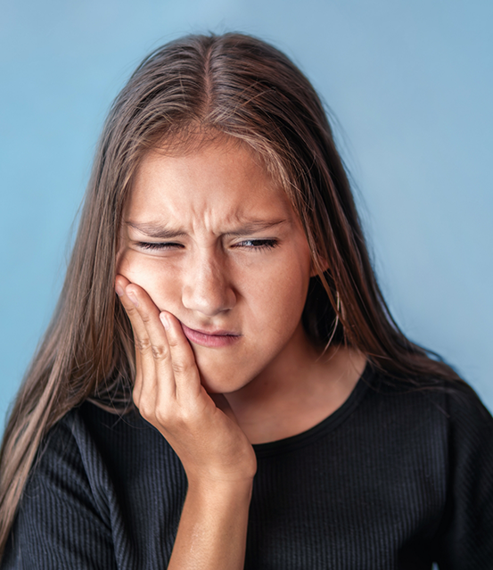 Girl holding the side of her face in pain