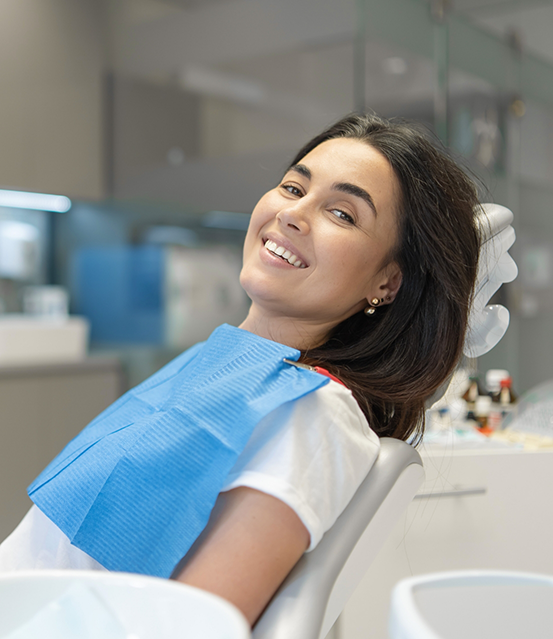 Smiling woman leaning back in the dental chair