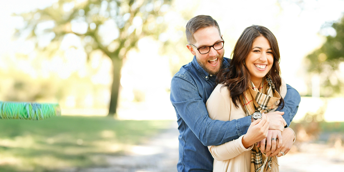 Smiling couple embracing outdoors after root canal treatment in Fort Worth