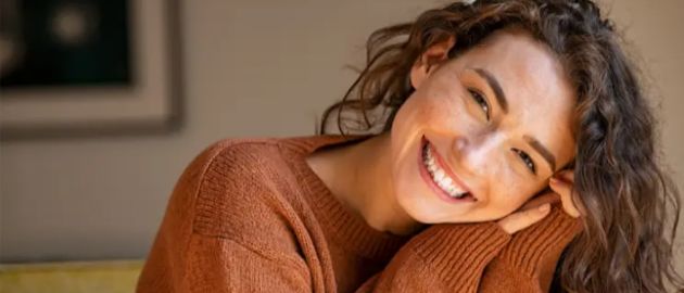 Smiling young woman in an orange sweater