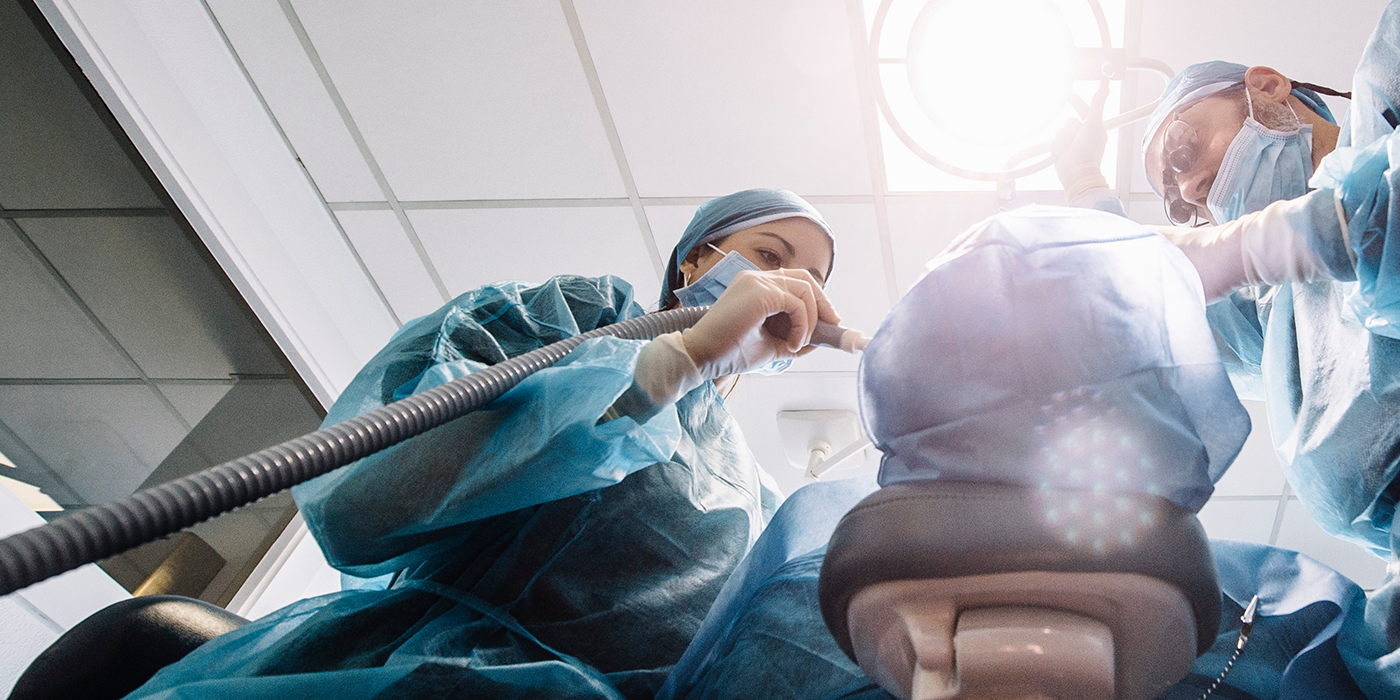 Dentist and assistant performing surgical tooth extractions in Fort Worth