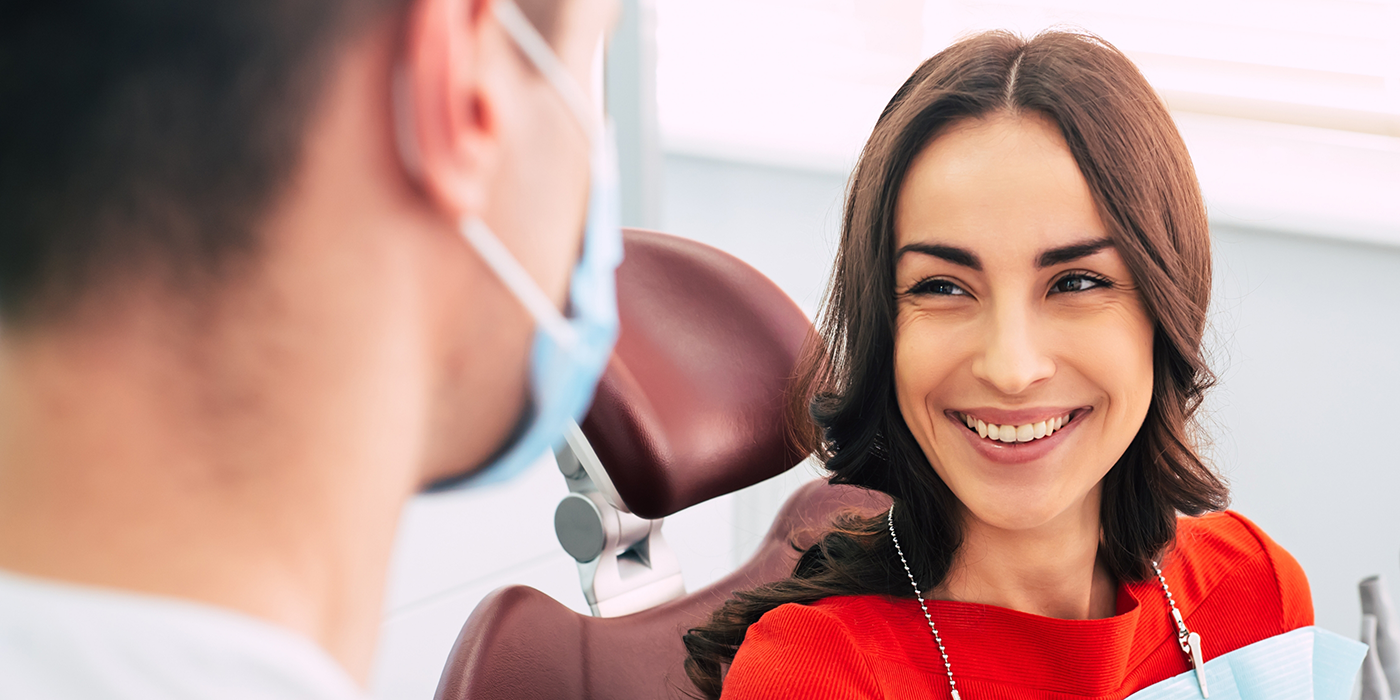 Woman smiling at her dentist after getting tooth colored fillings in Fort Worth