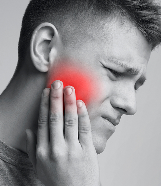 Young man holding the side of his face in pain